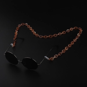 Close-up of tortoise shell acrylic eyeglass chain with black round sunglasses