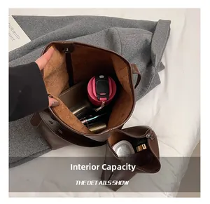 Internal capacity of the dark brown leather tote bag showing items and suede lining