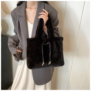Détail du sac cabas en fausse fourrure noire avec cordons et texture peluche sur modèle
