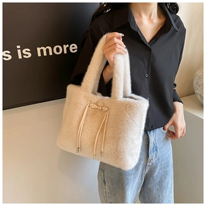 Gros plan du sac cabas en peluche beige avec un nœud décoratif et un cordon de serrage