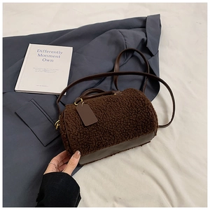 Dettaglio borsa boston in lana d'agnello marrone con finiture in pelle e fibbie dorate