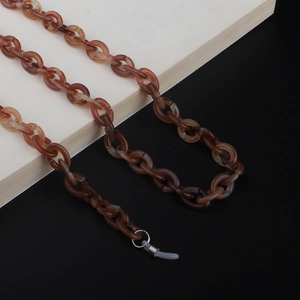 Macro detail of acrylic tortoise shell glasses chain with amber links and rubber loops