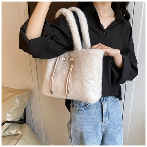 Détail du sac à main beige en peluche avec fourrure synthétique et cordon décoratif