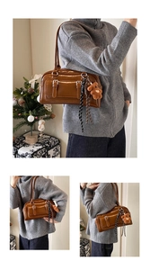 Close-up of brown retro Boston shoulder bag with teddy bear charm and striped scarf detail