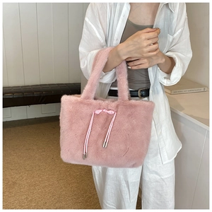 Détail du sac cabas en peluche rose avec un nœud décoratif en cordon de soie élégant