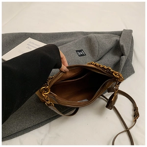 Innenansicht der braunen Ledertasche mit Stofffutter, Seitenfach und goldener Kette