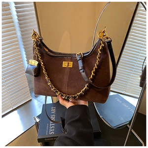 Nahaufnahme der braunen Wildleder-Beuteltasche mit goldener Kette und Mini-Münzfach-Anhänger