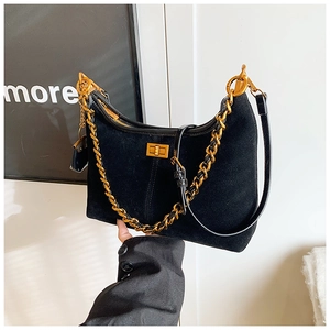 Detail der schwarzen Wildleder-Halbmondtasche mit goldener Kette und Metall-Drehverschluss