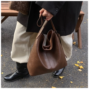 Detail of a dark brown large PU leather tote bag with a minimalist Hobo style design