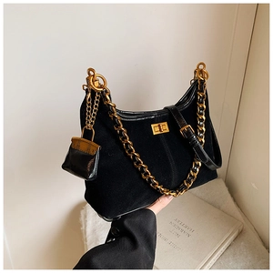 Detail der schwarzen Wildleder-Eimertasche mit goldener Kette und Drehverschluss-Design
