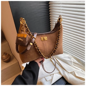 Detail der braunen Wildleder-Hobo-Tasche mit Goldkette und Mini-Taschenanhänger