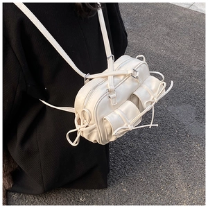 Detail of cream Boston bag in soft PU leather with functional pockets and bow drawstring