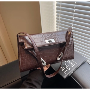 Close-up of brown crocodile pattern shoulder bag featuring silver metal twist lock