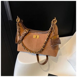 Detail der braunen Wildleder-Schultertasche mit Goldkette und Metall-Drehverschluss