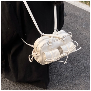 Detail of creamy white Boston bag with bow pockets and adjustable shoulder strap