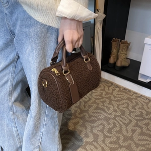 Borsa a cilindro marrone in shearling sintetico con manici in pelle per look invernale