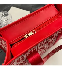 Close-up of golden zipper and red jacquard fabric texture on a bridal tote bag