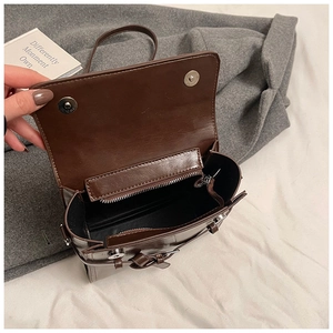 Detailed top view of brown oil-leather bag showing dual magnetic closure and zip compartment