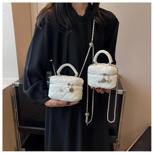 Detail of white quilted leather mini vanity bags with silver chain and camellia charm