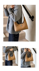 Dettaglio della borsa a spalla marrone vintage in pelle martellata con chiusura a scatto