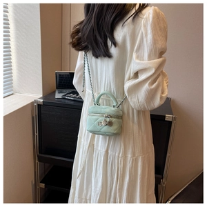 Quilted mint green mini bag showing crossbody style on model with silver chain strap