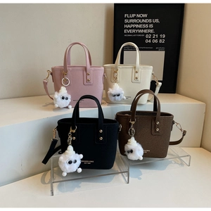 Chic mini bucket bags in multiple colors with plush monster charms and shoulder straps