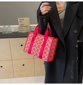 Detail of red wedding tote bag with traditional Xi embroidery and red ribbon handles