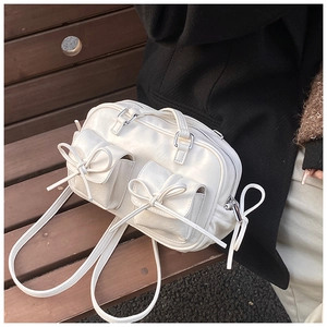 Detail of cream white leather Boston bag with double pockets and bow tie decoration