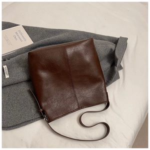 Detailed close-up of brown vintage leather tote bag with subtle wrinkled texture
