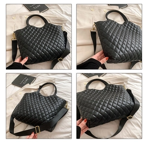 Detail view of black quilted tote bag with gold hardware and woven crossbody strap
