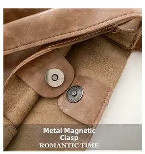 Dettaglio macro della chiusura magnetica in metallo su borsa tote in pelle marrone