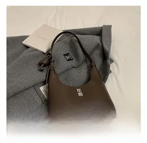 Dettaglio borsa hobo in pelle marrone scuro con chiusura a scatto e tracolla regolabile