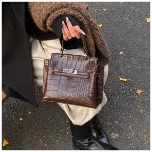 Dettaglio della trama a coccodrillo marrone scuro su una piccola borsa a tracolla vintage
