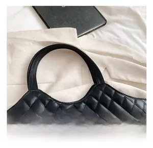 Close-up of quilted black leather tote bag with a round sturdy handle for comfortable grip