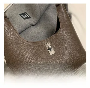 Dettaglio borsa in pelle martellata marrone scuro con chiusura a scatto in argento