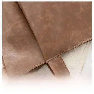 Dettaglio della borsa tote in pelle marrone con cuciture doppie e fibbia in metallo