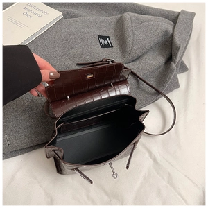Dettaglio interno della borsa marrone scuro con texture coccodrillo e fibbia