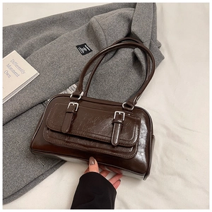 Detail of dark brown vintage oil-waxed leather handbag with metallic buckle and retro texture