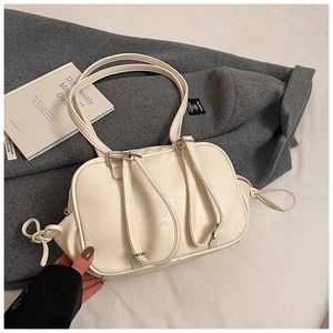 Detail of off-white leather Boston bag with dual straps and decorative side knots
