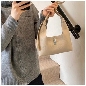 Dettaglio borsa hobo beige con trama in pelle martellata e fibbia rettangolare argento