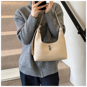 Dettaglio della borsa hobo in pelle beige con chiusura a rotazione in metallo argento