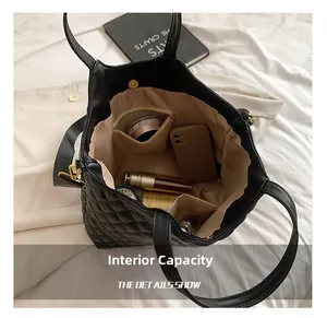 Interior view showing large capacity and internal pockets of black quilted tote bag