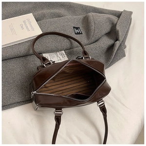 Detail view of the brown Boston bag interior with striped lining and zipper pocket