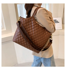 Detailed view of brown quilted tote bag with gold hardware and wide shoulder strap