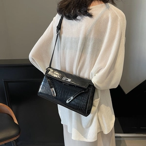 Classic black crocodile texture underarm bag with silver lock buckle worn by model