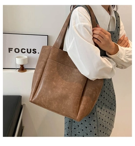 Dettaglio della borsa tote in pelle marrone vintage con grande capacità e trama morbida