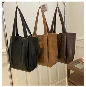 Dettaglio di tre borse tote minimaliste in ecopelle nei colori nero, marrone e caffè scuro