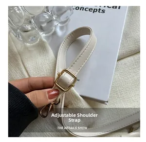 Detail showing adjustable cream leather strap with gold buckle and lobster clasp