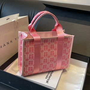 Pink festive tote bag with red Double Happiness embroidery and leather trim in high-end setting