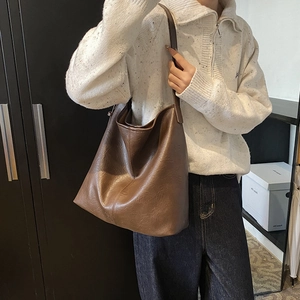 Deep brown oversized retro tote bag in textured faux leather shown with shoulder strap